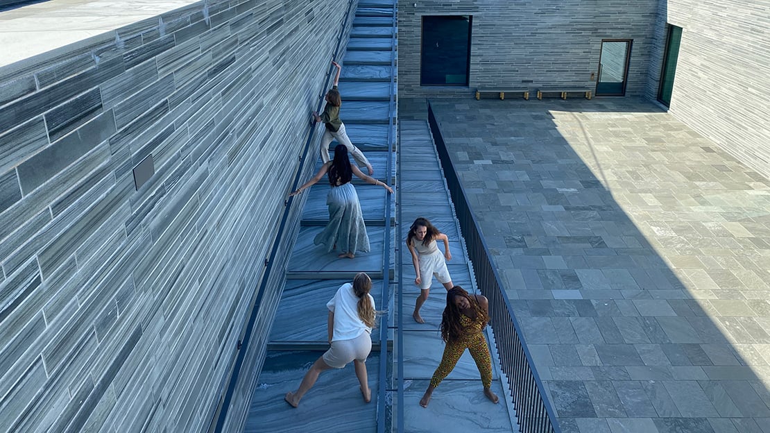Fem unge dansere i aksjon på taket av Nasjonalmuseet Fem dansere i en steintrapp