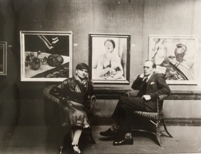 Seated woman and man in a gallery