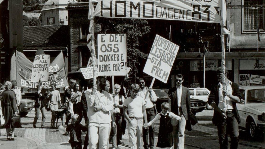 Folk i tog med bannere som sier "Homodagene 83", "e det oss dokker e redde for!?" og "Homofile, lesbiske - stå frem"