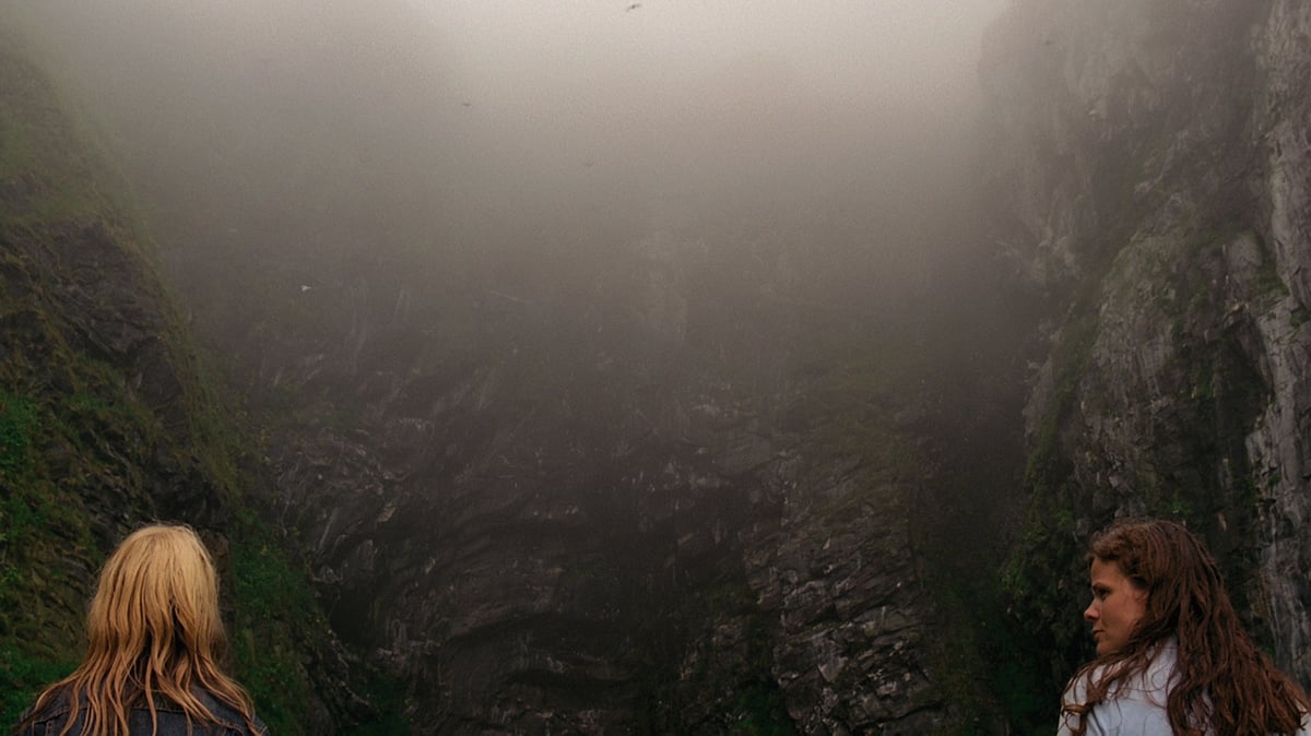 A K Dolven, «Moving Mountain», 2004 Vi ser to kvinner stående foran en stor fjellvegg, det er tykk tåke i lufta