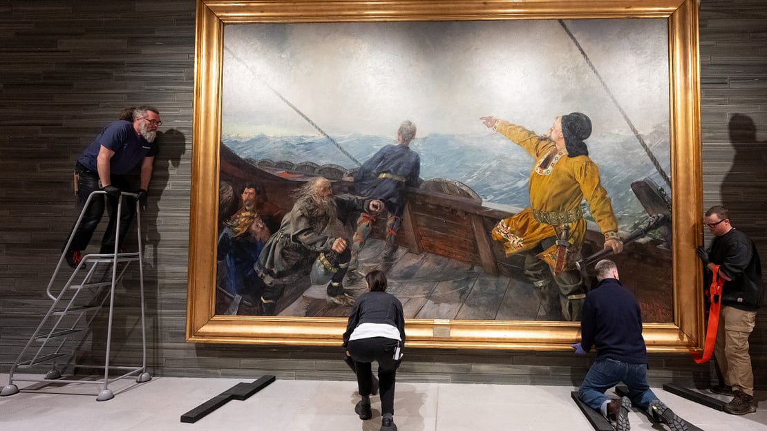 Museumsteknikere henger opp Christian Krohgs maleri "Leiv Eiriksson oppdager Amerika", i Nasjonalmuseet.