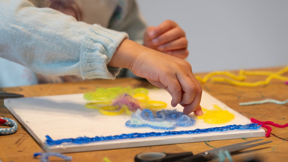 Broderiverksted i Nasjonalmuseet Hender som jobber med borrelåsbroderi