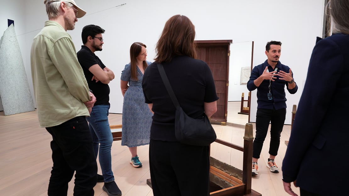 En gruppe tilhørere er med på en omvisning. De står rundt en del av verket "Bilde og kropp" av Michelangelo Pistoletto.