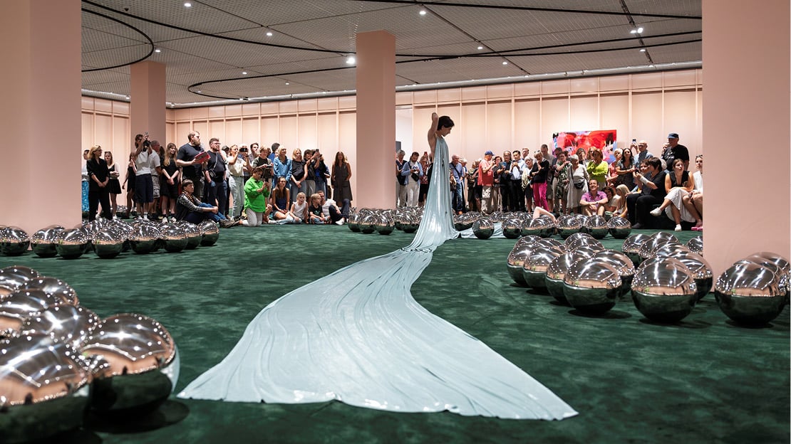 Image shows dancer and coreographer Øren wearing a costume by Thorbjørnsen, in the installation "Narcissus Garden" by Kusama.