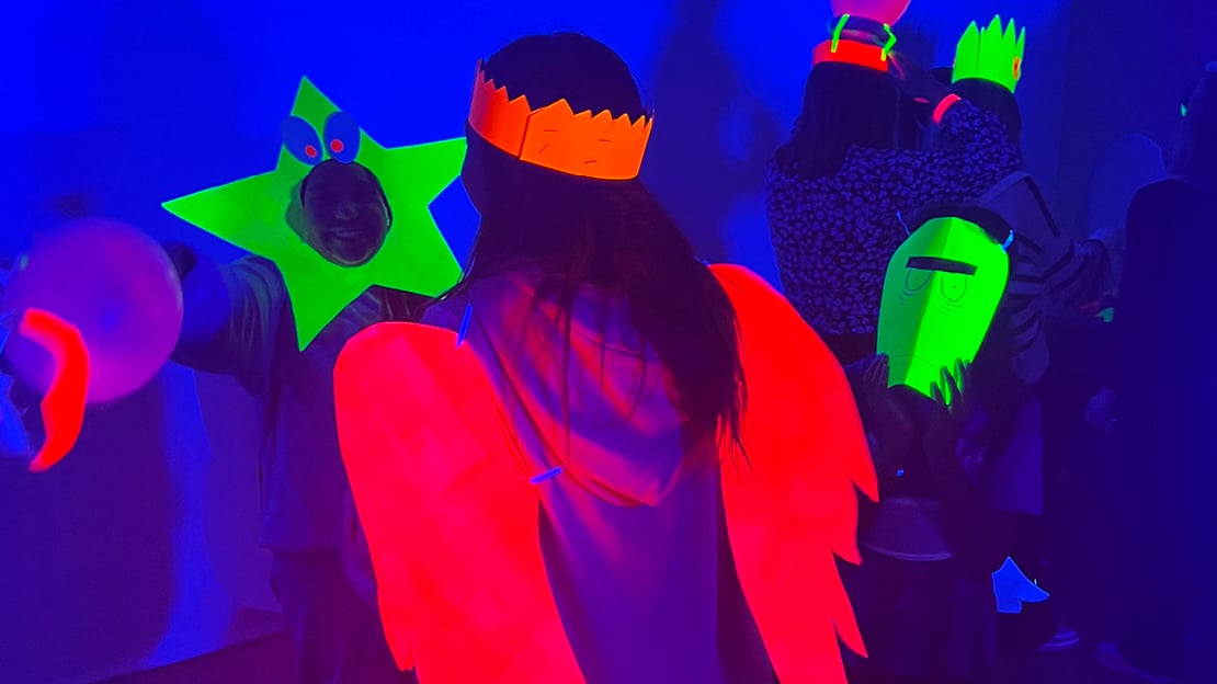 Dansende mennesker med neon kostymer