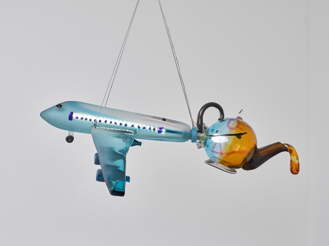 Hengende modell av fly med en tekanne i halen