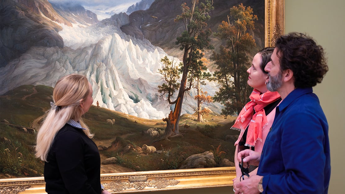 Research fellow Trine Nordkvelle, Director Ingrid Røynesdal and Thierry Ford, Head of Research and Development. Two women and a man in front of a large painting of a glacier.