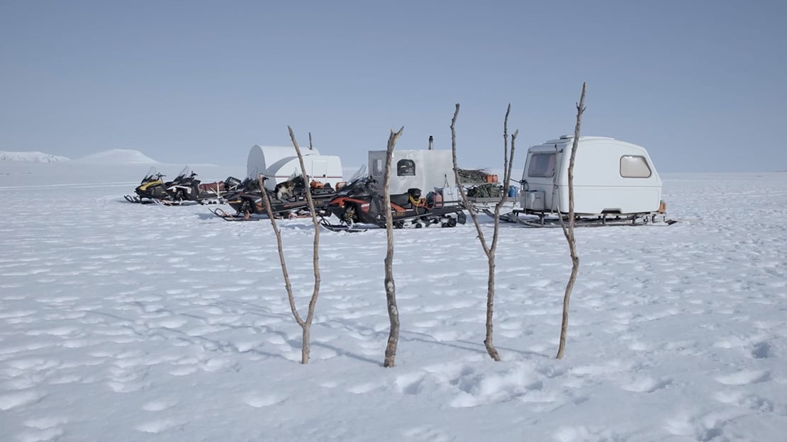 Fra episode fem av «Post-Capitalist Architecture TV» av Joar Nango og Ken Are Bongo, 2021 Vidde med snø. Snøscootere og tre campingvogner på meier.
