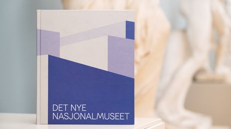 «Det nye Nasjonalmuseet» av Orfeus forlag/Nasjonalmuseet. Redaktør/hovedforfatter: Audun Vinger. Formgitt av Kørner & Ludvigsen. lilla bok med teksten "det nye nasjonalmuseet"