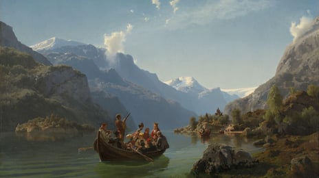 En båt med bundadskledde, feststemte mennesker i forgrunnen, en kirke og fjord med fjell i bakgrunnen
