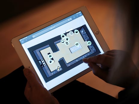 Datainnsamling i oktober 2024 med det digitale verktøyet SEEZ En person med et nettbrett med en digital plantegning av et rom med ikoner som representerer forskjellige elementer i rommet.