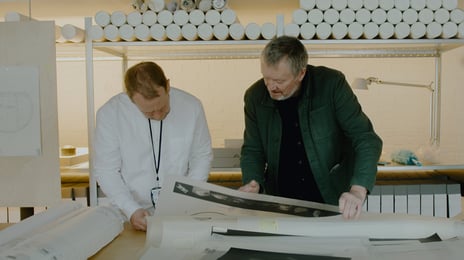 F.v. Joakim Skajaa, kurator i Nasjonalmuseet og Kjetil Trædal Thorsen, grunnlegger og arkitekt i Snøhetta. To menn står bøyd over arkitektplansjer.
