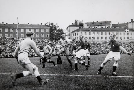 Svart-hvitt-bilde av menn som spiller fotball