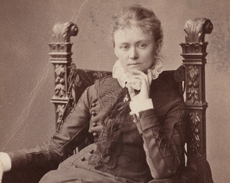 Sort-hvitt fotografi av sittende kvinne