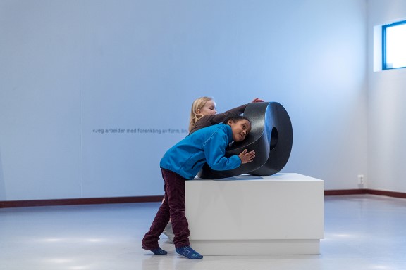 Barn kjenner på en skulptur laget av kunstner Aase Texmon Rygh.