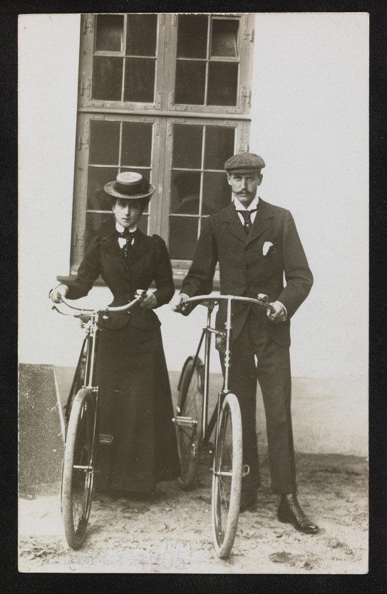 Prins Carl og prinsesse Maud med sykler. mann og kvinne med hver sin sykkel