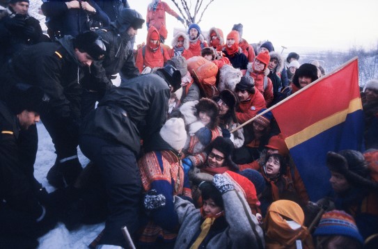 The police remove demonstrators blocking the road leading to the construction site in Stilla in January 1981. Photo of police and protesters, some of which have sami attire.