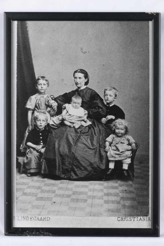 Edvard Munchs mor, med de 5 barna Inger Marie, Johanne Sophie, Peter Andreas, Laura Cathrine og Edvard Munch stående til høyre. En kvinne med fem barn hos fotografen på 1800-tallet
