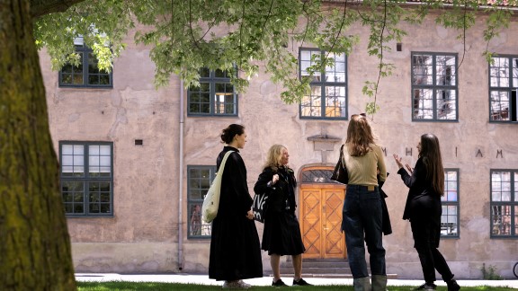 Fire damer står under et tre