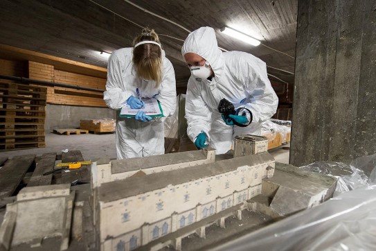 When conservators have to work with mold-infested material, special work outfits, with gloves, suits and masks, are in order.
