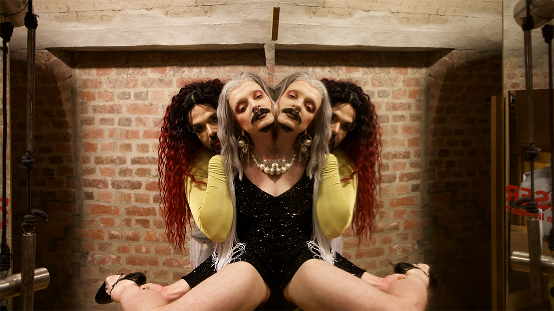 Two persons whit mustash, long hair. Photo is mirrored in the middle = four heads.