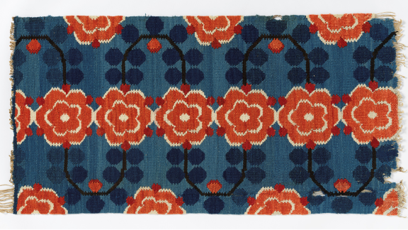 Vevet tekstil, med mønster av rød og hvite stokkroser på blå bunn