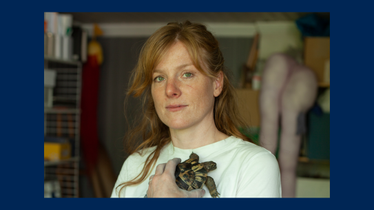 Kunstner Jennie Bringaker. Fotografi av kunstner Jennie Bringaker som holder en levende skilpadde inntil brystkassen.