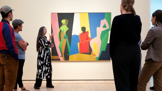 Bli med på omvisning i Nasjonalmuseet! En kvinne står foran et fargerikt kunstverk og snakker engasjert
