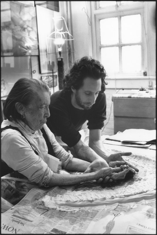 Louise Bourgeois and her assistant Jerry Gorovoy, in her Brooklyn studio preparing to make a mold for a sculpture in 1995. Older woman and adult man preparing an art work