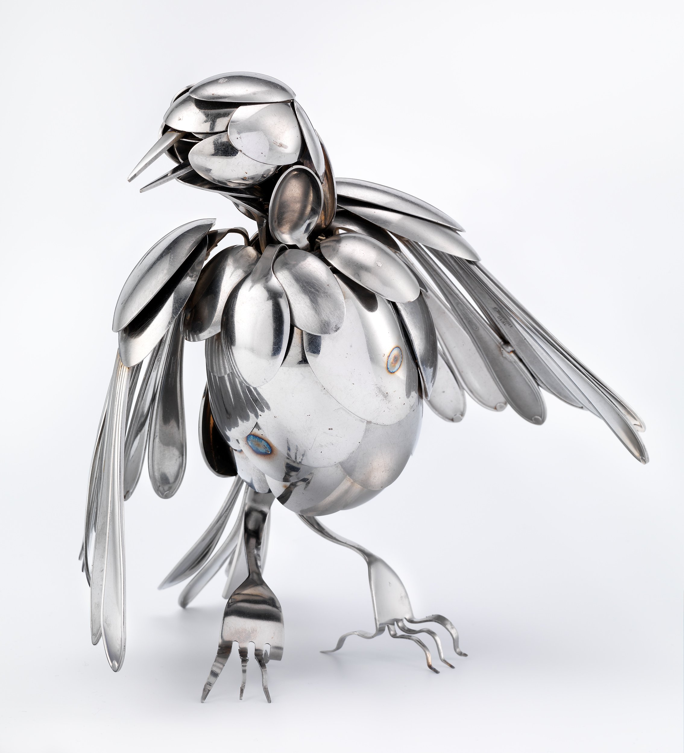 Fugl laget med sølvskjeer. Sølvgafler som føtter.