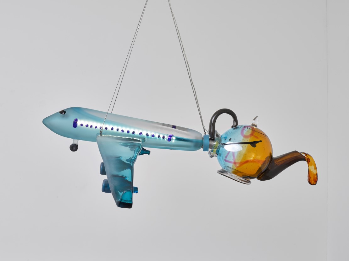 Hengende modell av fly med en tekanne i halen