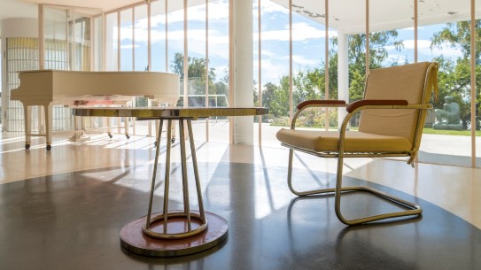 Villa Stenersen En stol, et rundt bord og et flygel i en funkisvilla med store vinduer