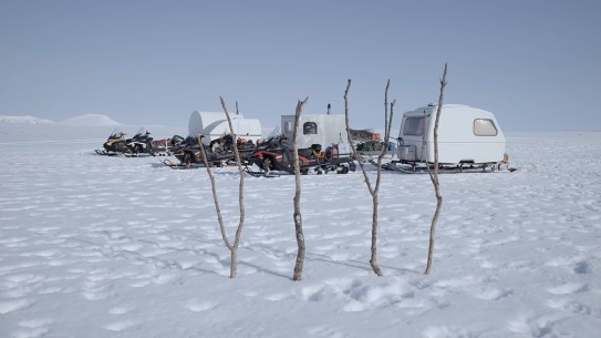 Fra episode fem av «Post-Capitalist Architecture TV» av Joar Nango og Ken Are Bongo, 2021 Vidde med snø. Snøscootere og tre campingvogner på meier.