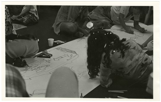 "Women’s environmental fantasy drawings workshop" ble organisert flere steder i USA på 1970-tallet av arkitekten Phyllis Birkby. kvinner på gulvet tegner på et stort papir